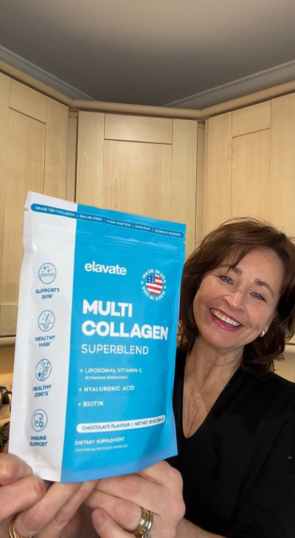 Woman smiling and holding a blue elavate Multi Collagen Superblend pouch in a kitchen